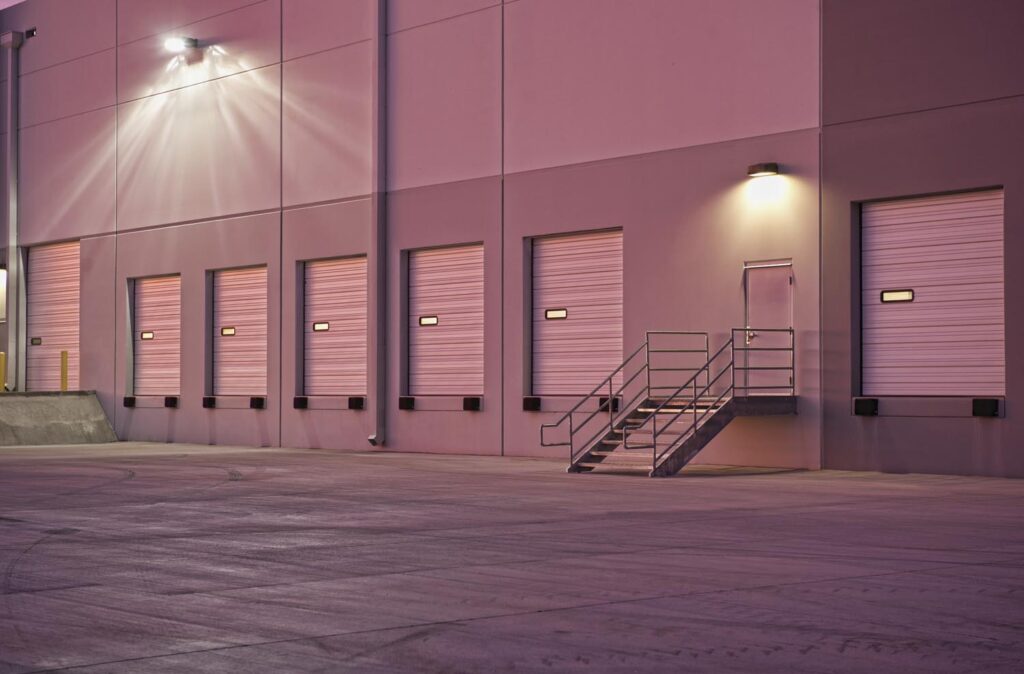 A series of loading dock equipment and overhead doors at a warehouse