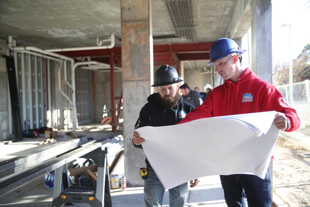 John and Jason of Commercial Door reviewing plans for an overhead door project